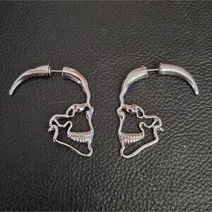 Skull shaped through-ear illusion earrings
